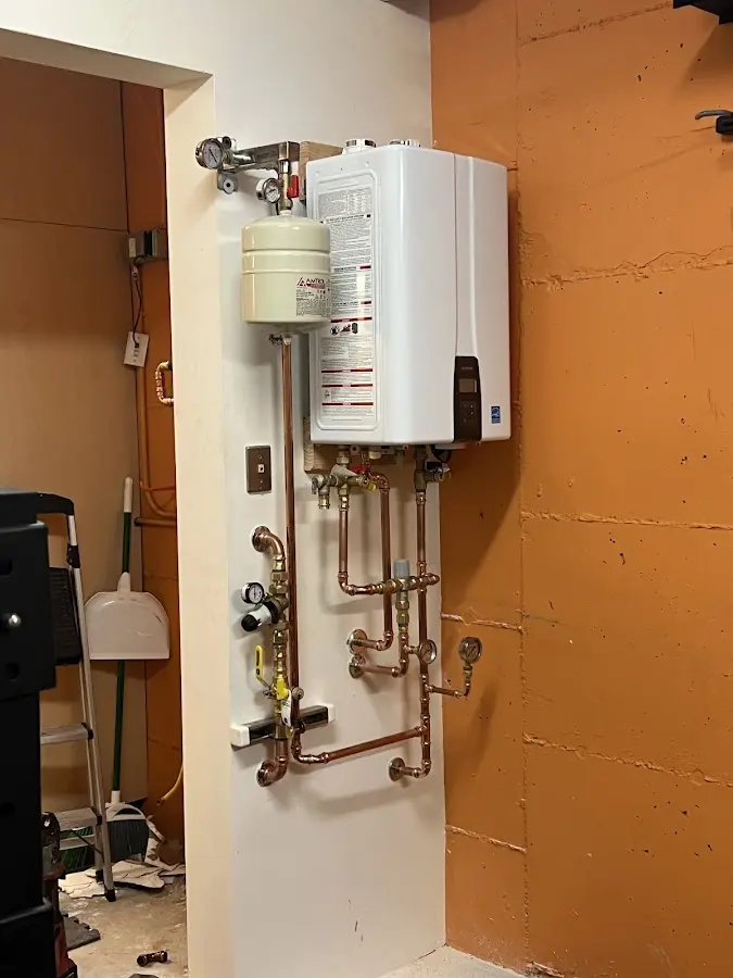 Plumbing technician inspecting water heater connections in Fussels Corner